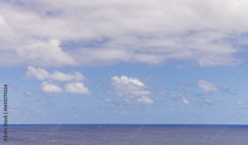 Fototapeta premium Serene Ocean Horizon With Soft Clouds in a Clear Blue Sky