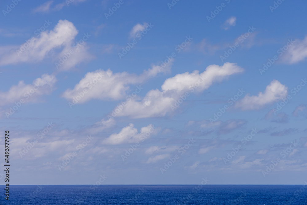 Obraz premium Bright Sky and Ocean Horizon with Scattered Clouds on a Sunny Day