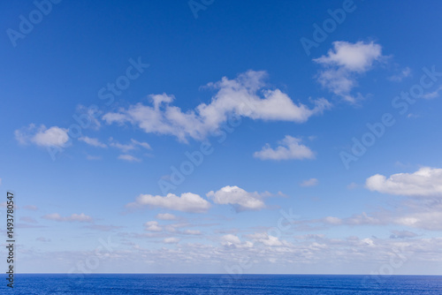 Blue Sky With Clouds Over the Calm Pacific Ocean Horizon