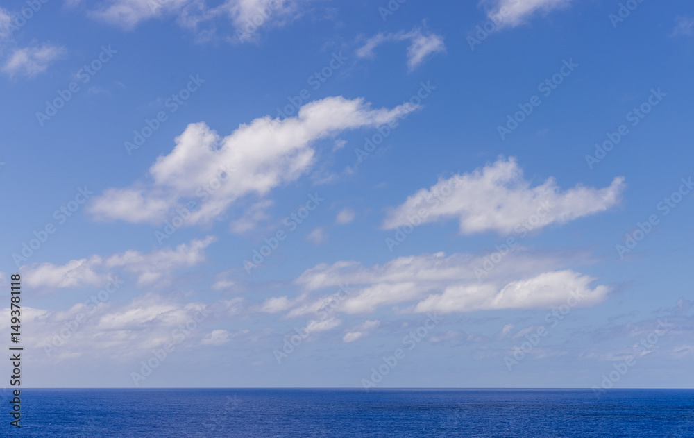 Obraz premium Tranquil Blue Ocean with Stunning Cloudscape Under a Bright Sky
