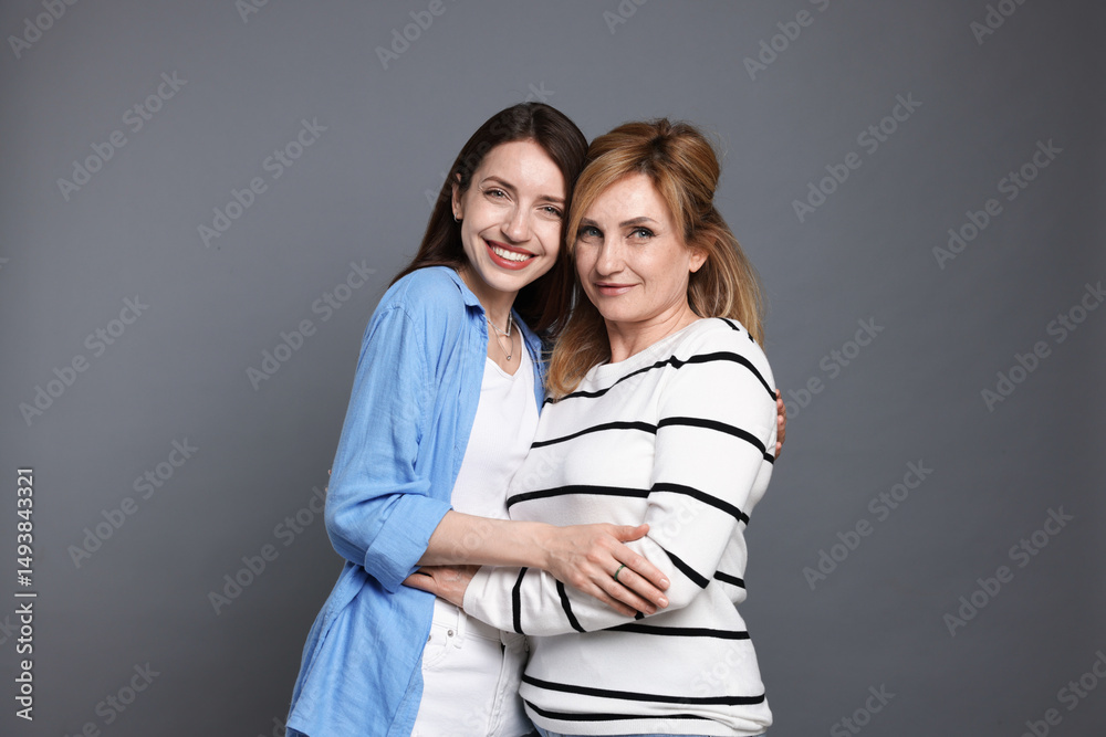 Portrait of mother and daughter on grey background Portrait of mother and daughter on grey background