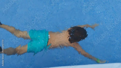 A boy is swimming in a pool