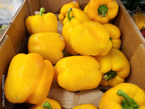 Yellow bell peppers in a cardboard box, Fresh yellow peppers in store, Sweet peppers