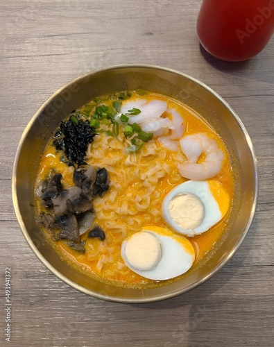 Appetizing ramen bowl with seafood and eggs