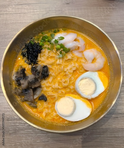 Delicious ramen with seafood and egg on wooden table
