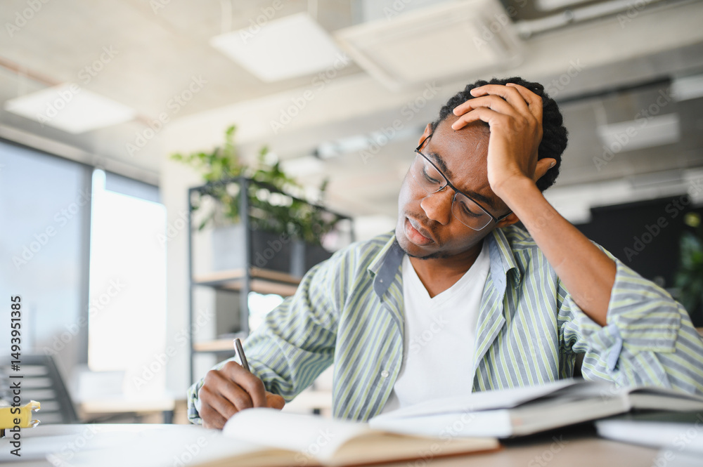 Focused african american student studying hard in university library Focused african american student studying hard in university library