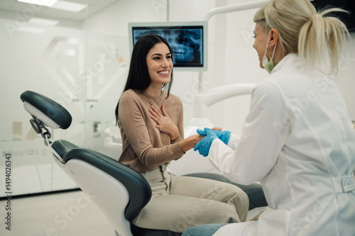 Female dentist reassuring patient before dental procedure photo