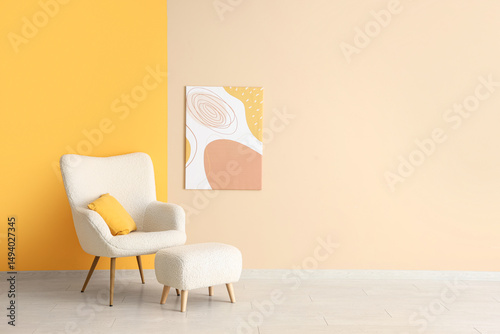 White armchair, pouf and picture on colorful wall in room