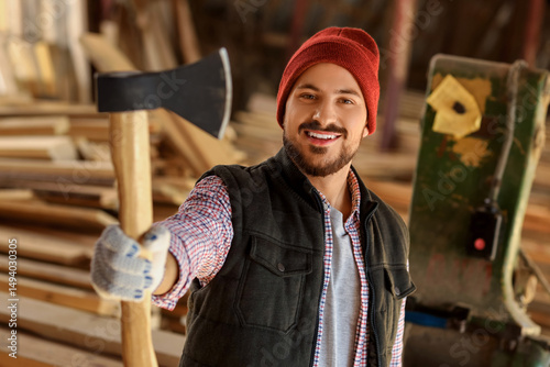 Young carpenter with axe at...