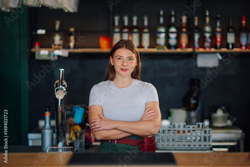 Фотография Bartender smiling with crossed arms behind bar counter