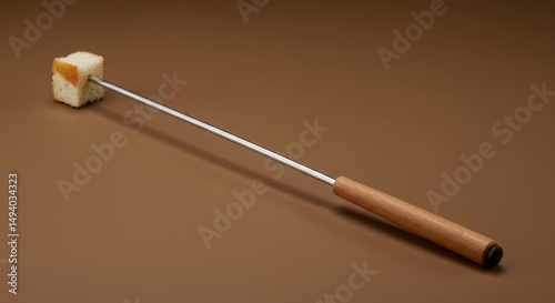 Fondue time: a studio shot showcasing a piece of bread skewered on a fondue fork