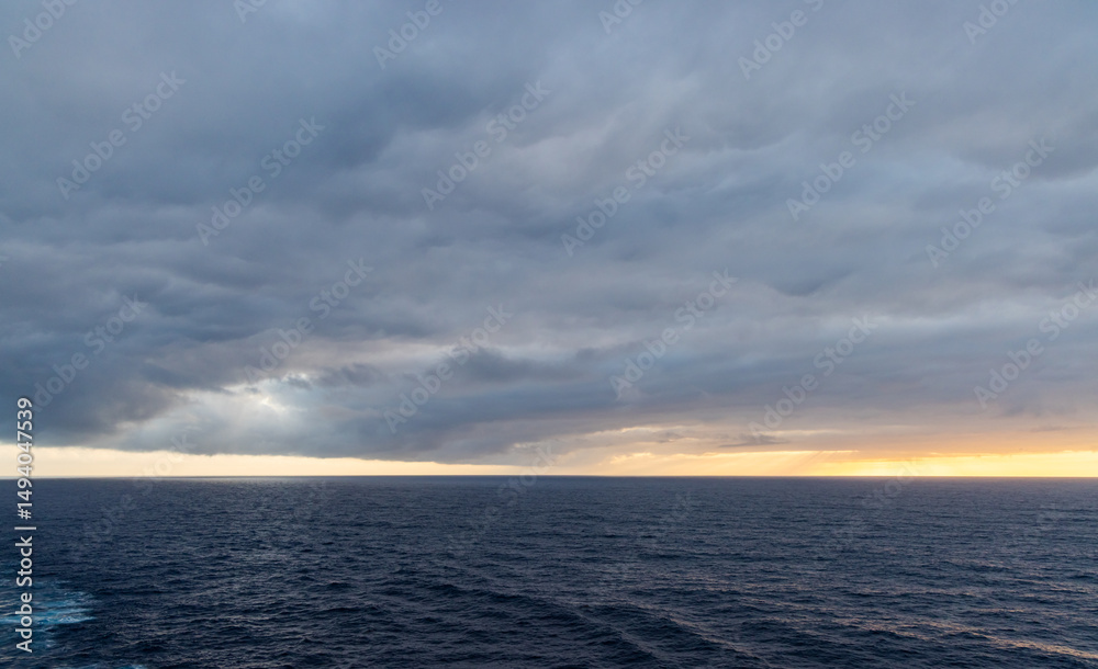 Obraz premium Dramatic Ocean Horizon With Stormy Clouds and Sunset Glow
