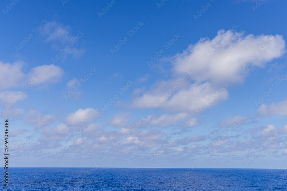 Fototapeta premium Blue Ocean With Clouds Under a Clear Sky Over the Pacific Ocean