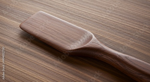Elegant wooden cheese spreader showcasing craftsmanship on rustic wood surface