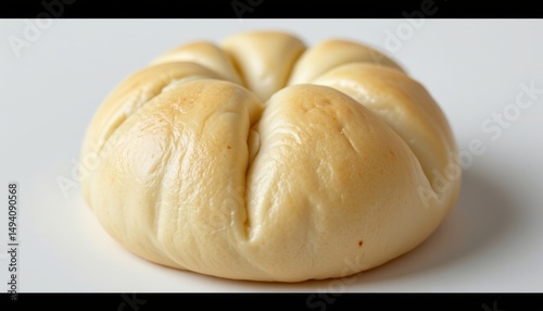 manju steamed bun with a smooth pale outer layer made from flour dough, filled with red bean paste, perfectly round with a subtle sheen, representing a humble classic of japanese confectionery photo