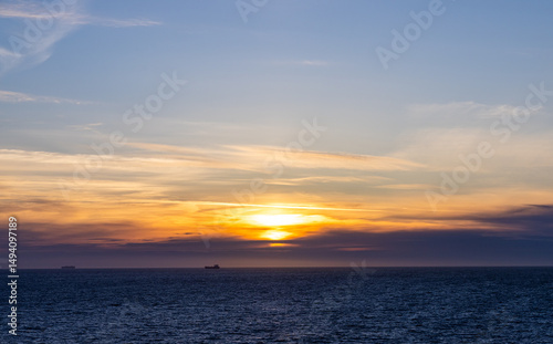 Bright Sunset Over Tranquil Pacific Waters with Golden and Orange Skies