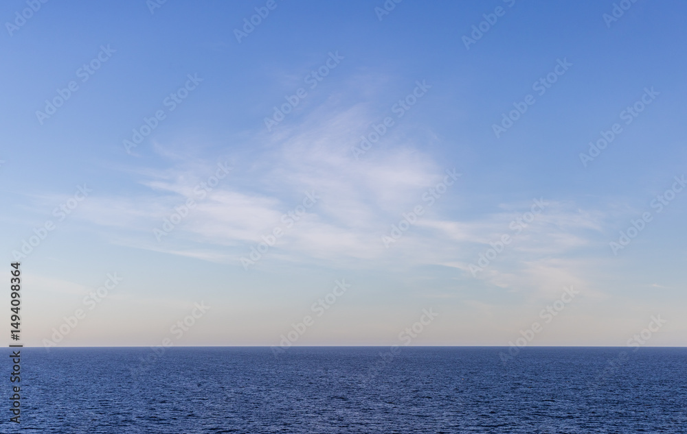 Obraz premium Serene View of Ocean with Clear Sky and Wispy Clouds at Daytime