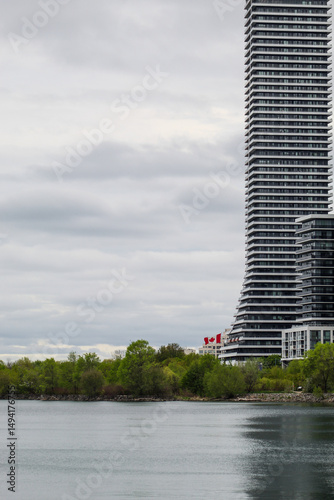 Canadian flag blowing in wind along Humber Bay on Lake Ontario, Toronto