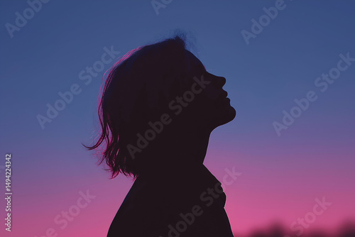 Woman silhouette looking up at vibrant sunset sky in contemplation, People and Portraits with Bokeh Concept