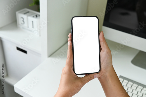 A person holding a cell phone with a white background.
