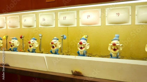 A classic water gun clown balloon carnival game. Old, aged looking clown heads and numbered flashing lights.