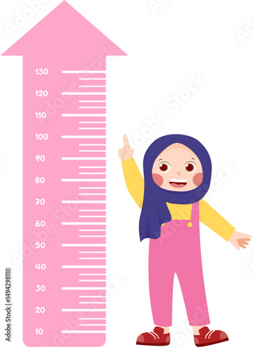 Girl in hijab measuring her height on a pink arrow wall chart.