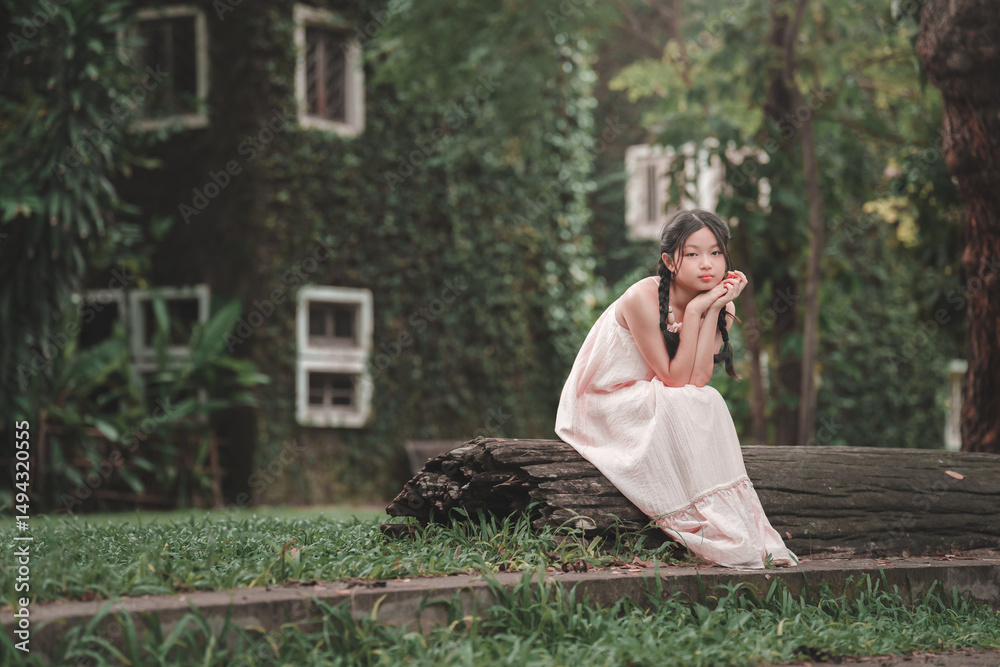 Fototapeta premium Contemplative teenage girl sitting on log serene nature outdoor portrait peaceful setting