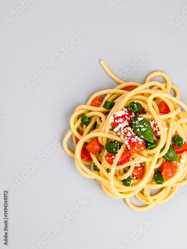 Pasta with vegetables is seasoned with salt on a gray background. Too much salt in food is unhealthy. It is necessary to salt food in moderation