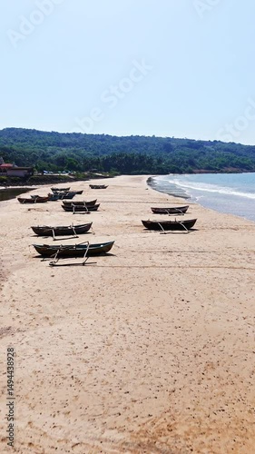 Vertical drone shot over traditional Dhoni fishing vessels, on a beach in India photo