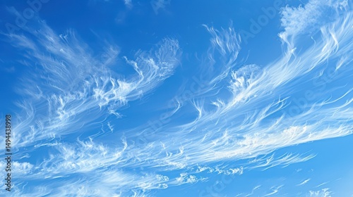 A serene view of a bright blue sky filled with wispy cirrus clouds creating a peaceful atmosphere