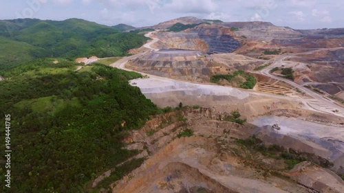 Gold and Silver mine in green forest landscape of Cotui, Dominican Republic. Slow forward wide shot. Mountains and hills at mining complex area. photo