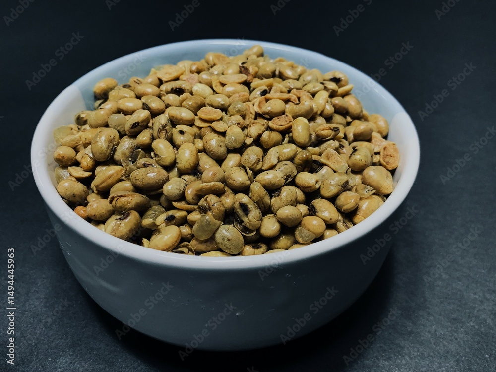 Fried soybeans in a bowl on dark background. Fried soybeans in a bowl on dark background.