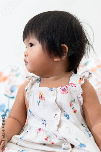 One year old asian girl in floral dress indoor setting lifestyle portrait cute expression