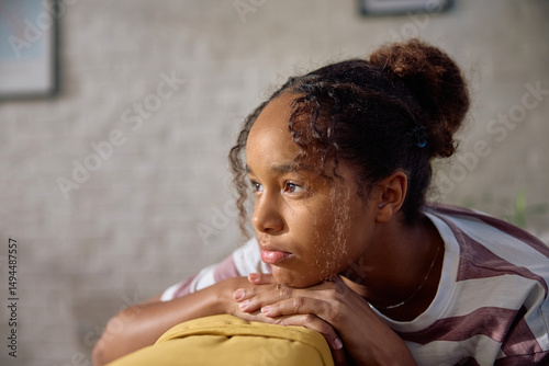 Thoughtful black teenage girl at home.