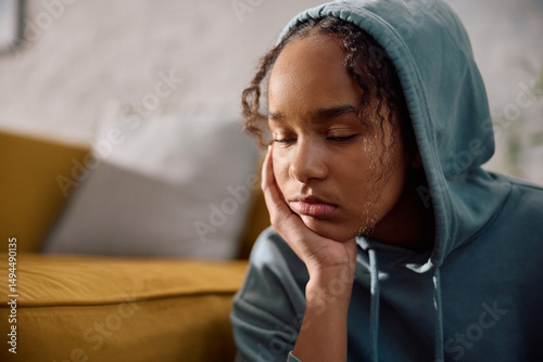 Depressed black teenage girl at home.