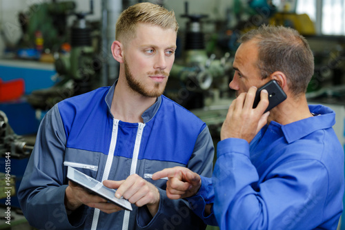 Tableau sur toile mechanic in car repair shop talking on phone