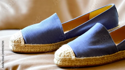 Elegant summer footwear pair featuring light blue espadrilles with woven jute soles, showcasing simplicity and beach style appeal.