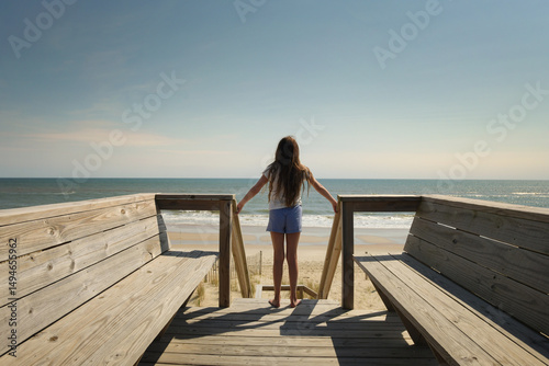 Profile tween girl standing on top boardwalk sunny blue sky Oute