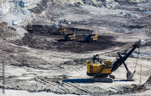 Panoramic aerial view of coal mine. Open pit mine industry, big yellow mining truck for coal quarry. Open coal mining anthracite mining. Pit on coal mining by open way. 