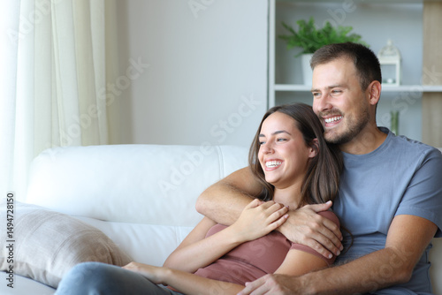 Happy couple hugging relaxing on a couch at home
