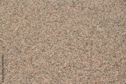 A close up of a stone surface with a lot of small rocks. The surface is brown and has a lot of texture