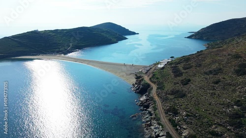 Coastal aerial overview of Kythnos island at golden hour with rugged terrain and calm water reflections, approach to Kolona Beach photo