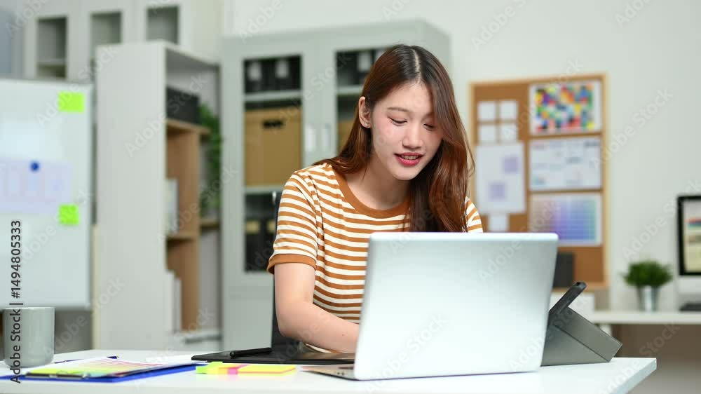 Young female designer using pen tablet and color palette while working in a modern creative office and color theory themes. Young female designer using pen tablet and color palette while working in a modern creative office and color theory themes.