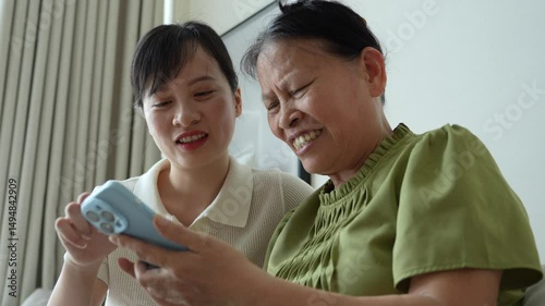 Young Asian woman teaching her mother to using smartphone