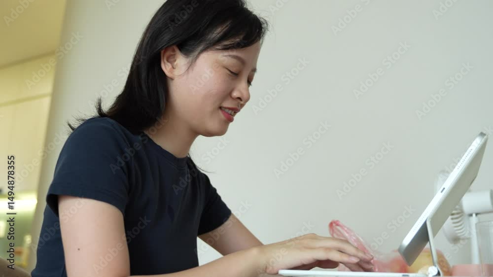 Young Asian woman using tablet for working at home
