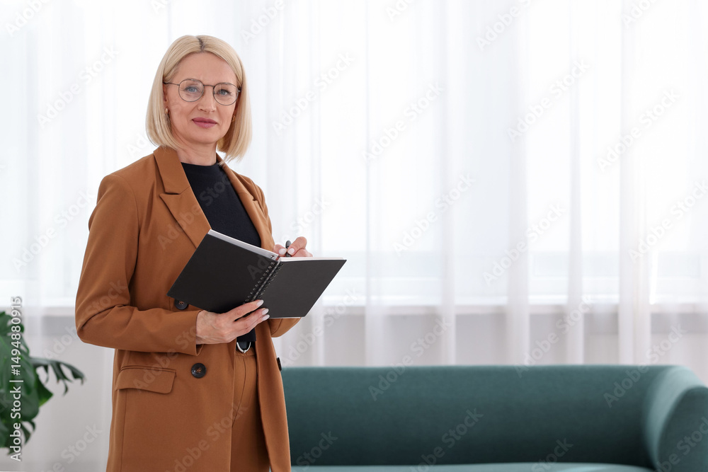 Fototapeta premium Professional psychologist writing in notebook indoors, space for text