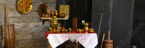 Traditional russian table setting with khokhloma decorated dishes, samovar, and embroidered tablecloth, reflecting russian folk art and culture.
