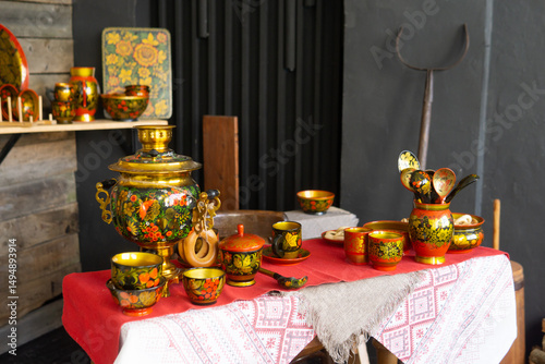 Traditional Khokhloma folk craft table setting with samovar, spoons, and snacks. Russian tea drinking food and decorative tableware for cultural design background.