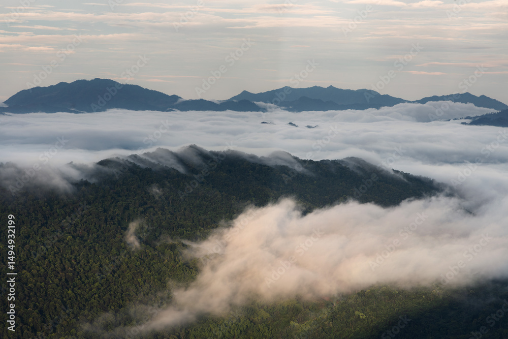 Obraz premium Morning fog and clouds descending over the mountain peaks and into the valley of remote parts of northern Vietnam