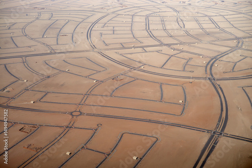 Aerial view of a desert landscape with winding roads and sparse building plots. Abu Dhabi, UAE